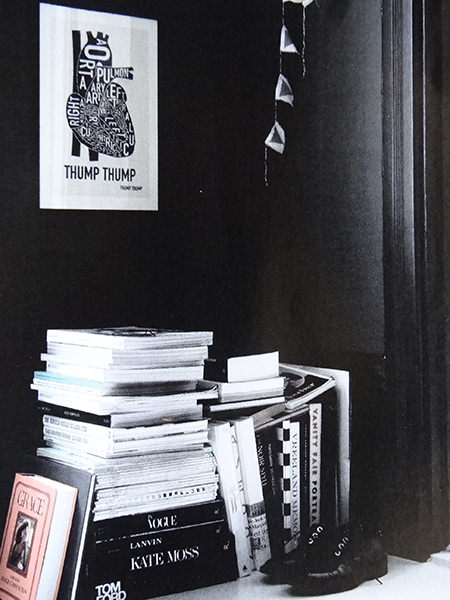 Dark painted walls with pile of books in a corner in a monochromatic home Dark painted walls with pile of books in a corner in a monochromatic home