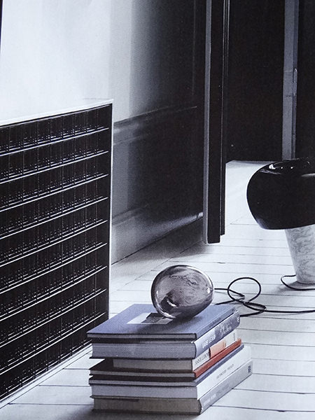 Glass balloon light on a pile of books on the floor of a monochromatic home Glass balloon light on a pile of books on the floor of a monochromatic home