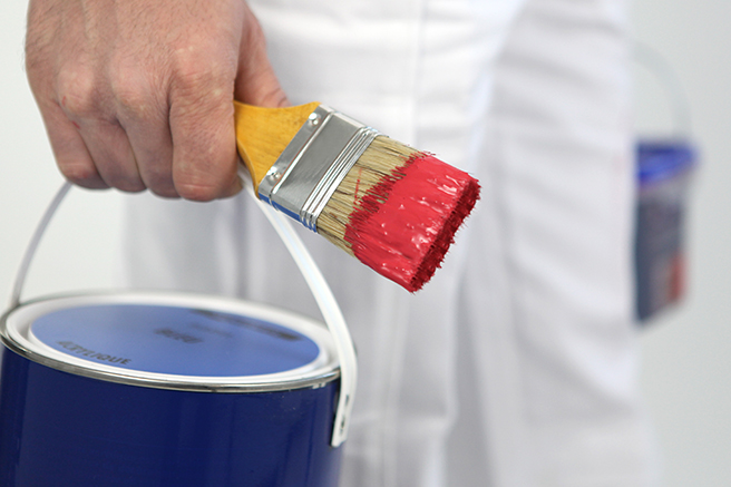 Painter/decorator carrying tins of paint and paintbrush Painter/decorator carrying tins of paint and paintbrush