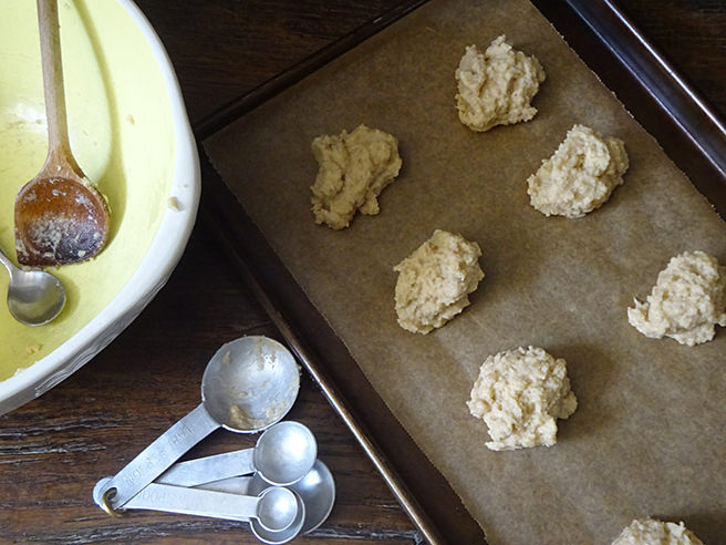 Spoonfuls of almond banana cookie dough on a lined baking tray | H is for Home