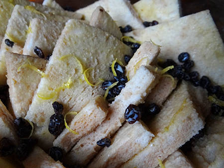 bread sprinkled with custard mix, currants and lemon zest