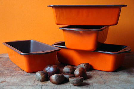 stack of orange cake tins and handful of chestnuts