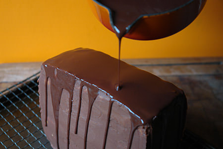Pouring chocolate glaze on to the chocolate caramel chestnut cake