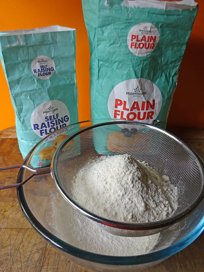 Sifting flours into a glass mixing bowl | H is for Home