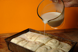 Pouring sweetened coconut milk on the risen panipopo dough | H is for Home