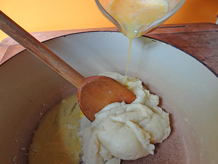 adding eggs to profiterole batter