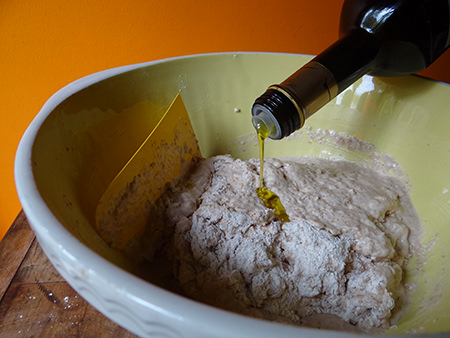 Adding olive oil to Roman bread dough