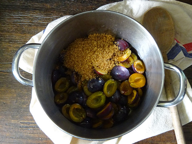 Sliced & stoned plums in a saucepan with Demerara sugar and mixed spice