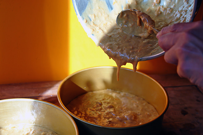 Pouring sweet potato cake batter into cake tins