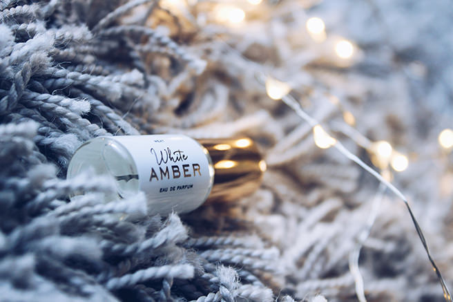 Little bottle of white amber room scent spray on a shaggy rug