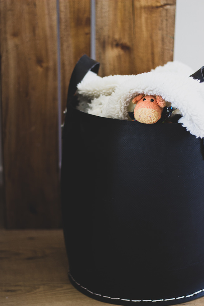 Storage basket with stuffed toy pig and fluffy blanket