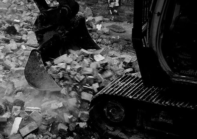 mini-digger clearing pile of bricks