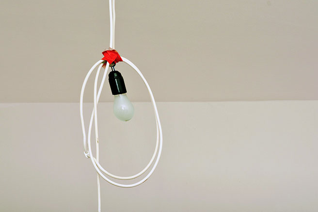 Bare lightbulb hanging from a wound up flex