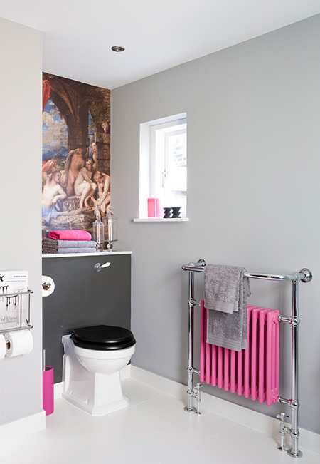 Bubble gum pink radiator, toilet brush holder and hand towel on a cloakroom