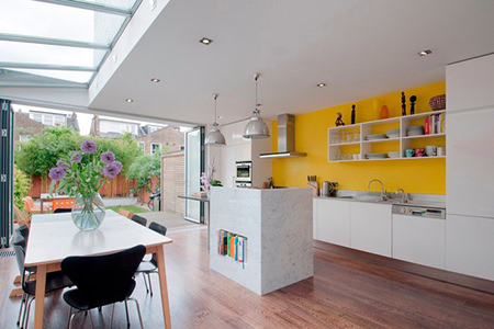 open plan kitchen diner with bright yellow feature wall