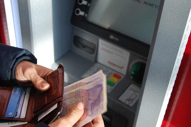 Person withdrawing money from a cash point machine