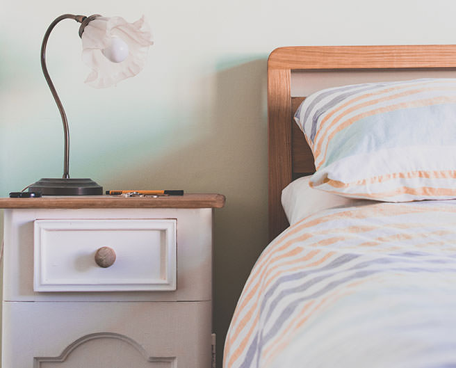 Bed with edside lamp on a side table