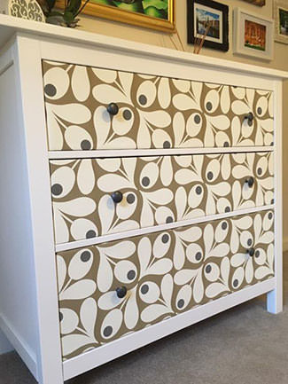 Drawers of a chest of drawers customised with wallpaper